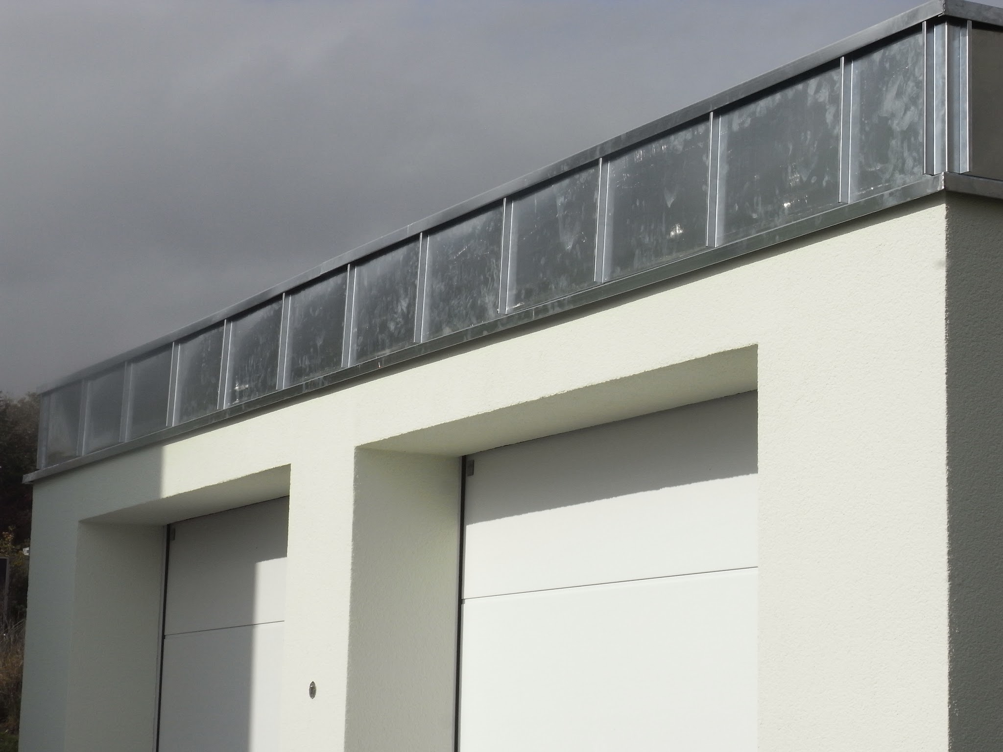 Attikaverkleidung aus Blech und Glas über der Garage