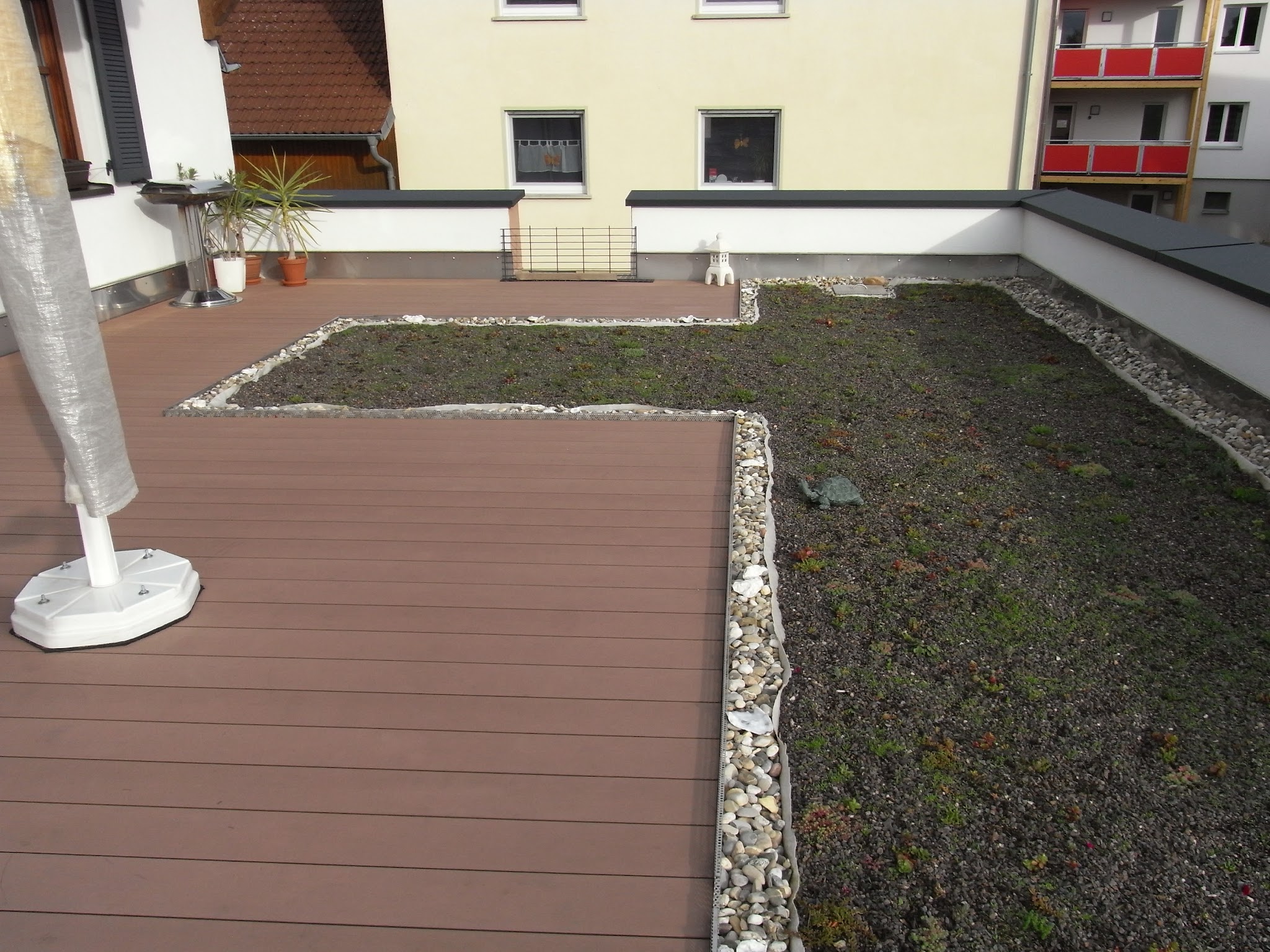 Fertiggestellte Dachterrasse mit Kiesbeet und WPC-Belag